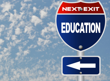 Road sign pointing left and saying Next Exit Education